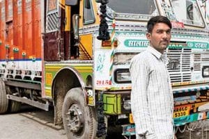 Sandeep Kumar, 24 truck driver outisde his truck.